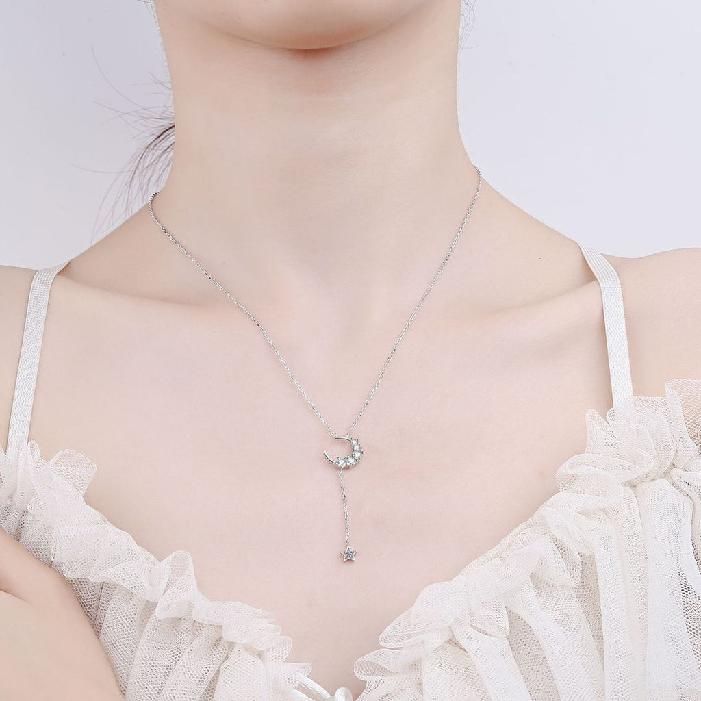 Moon and Star Moissanite Pendant Necklace in Rhodium-Plated S925 sterling silver worn on neckline by model showing scale and adjustable chain styling