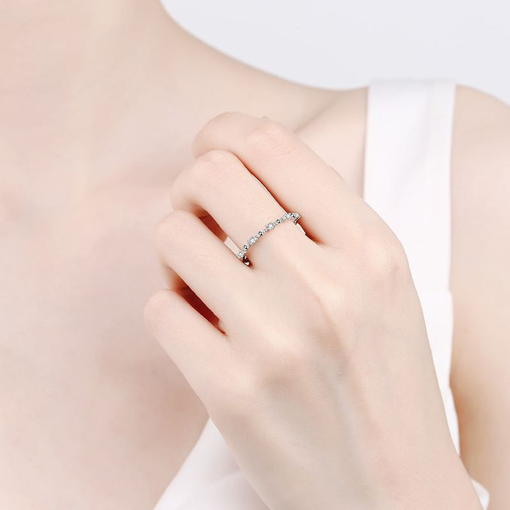 Delicate Round Moissanite Band Ring worn on hand to show scale and ring profile