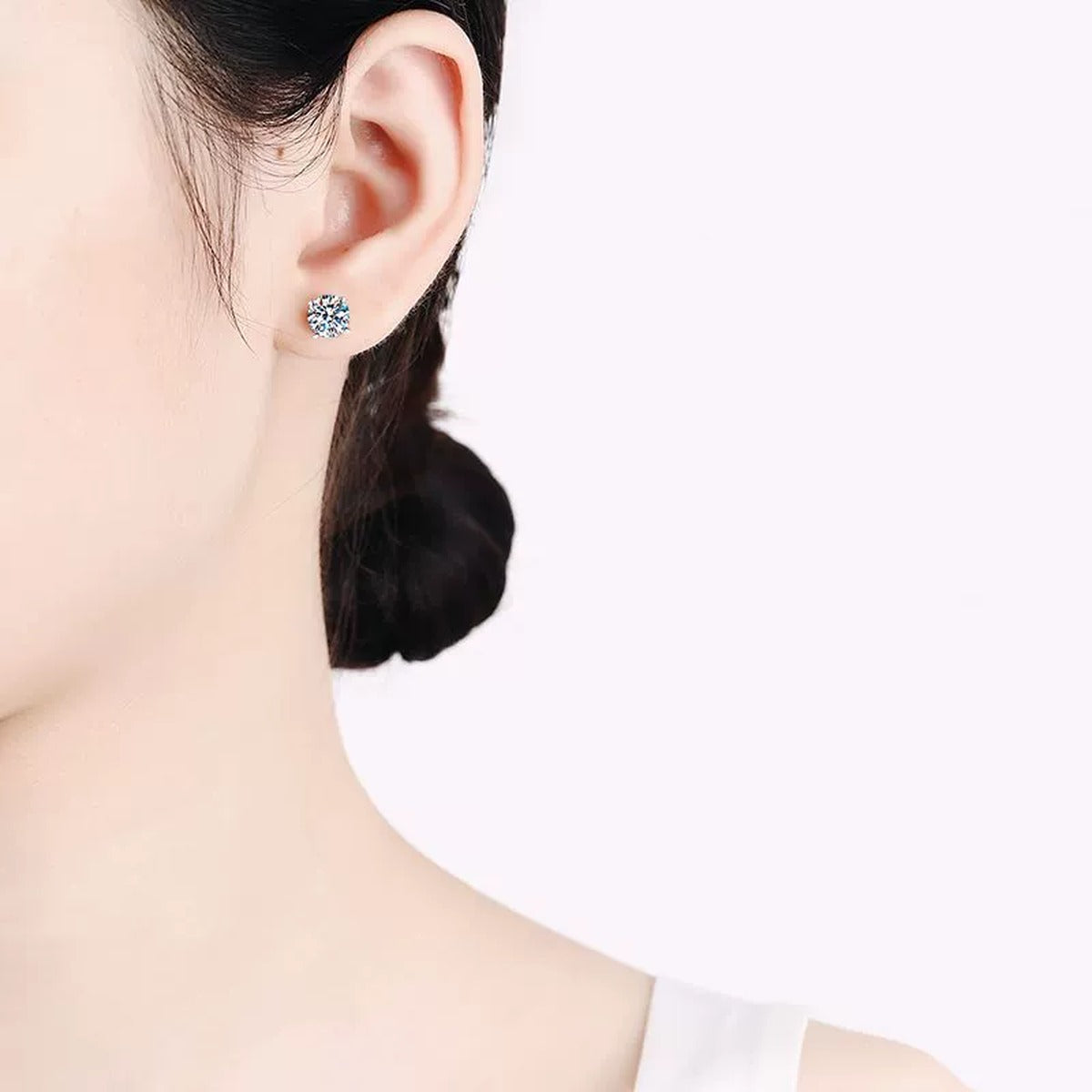 Round Moissanite Stud Earrings in Rhodium-Plated S925 sterling silver worn on ear by model showing scale, placement, and stud earrings styling