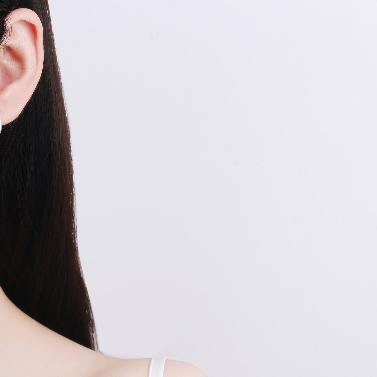 Minimal Huggie Hoop Earrings in Rhodium-Plated S925 sterling silver worn on ear by model showing scale, placement, and huggie hoop earrings styling