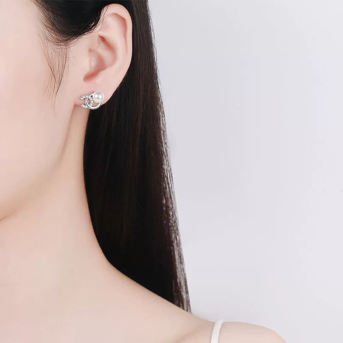 Swirl Pearl Moissanite Stud Earrings in Rhodium-Plated S925 sterling silver worn on ear by model showing scale, placement, and stud earrings styling