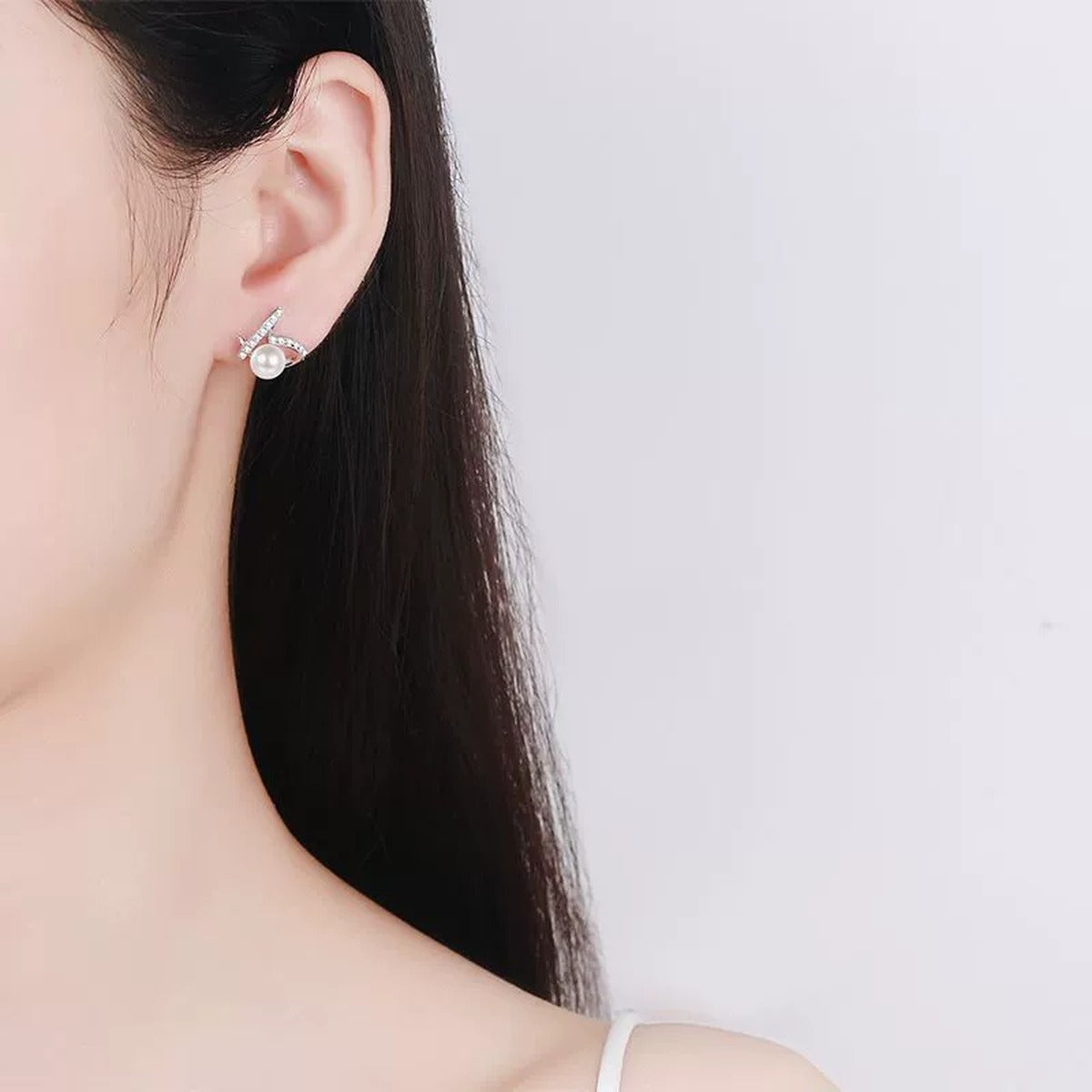 Ribbon Pearl Moissanite Stud Earrings in Rhodium-Plated S925 sterling silver worn on ear by model showing scale, placement, and stud earrings styling