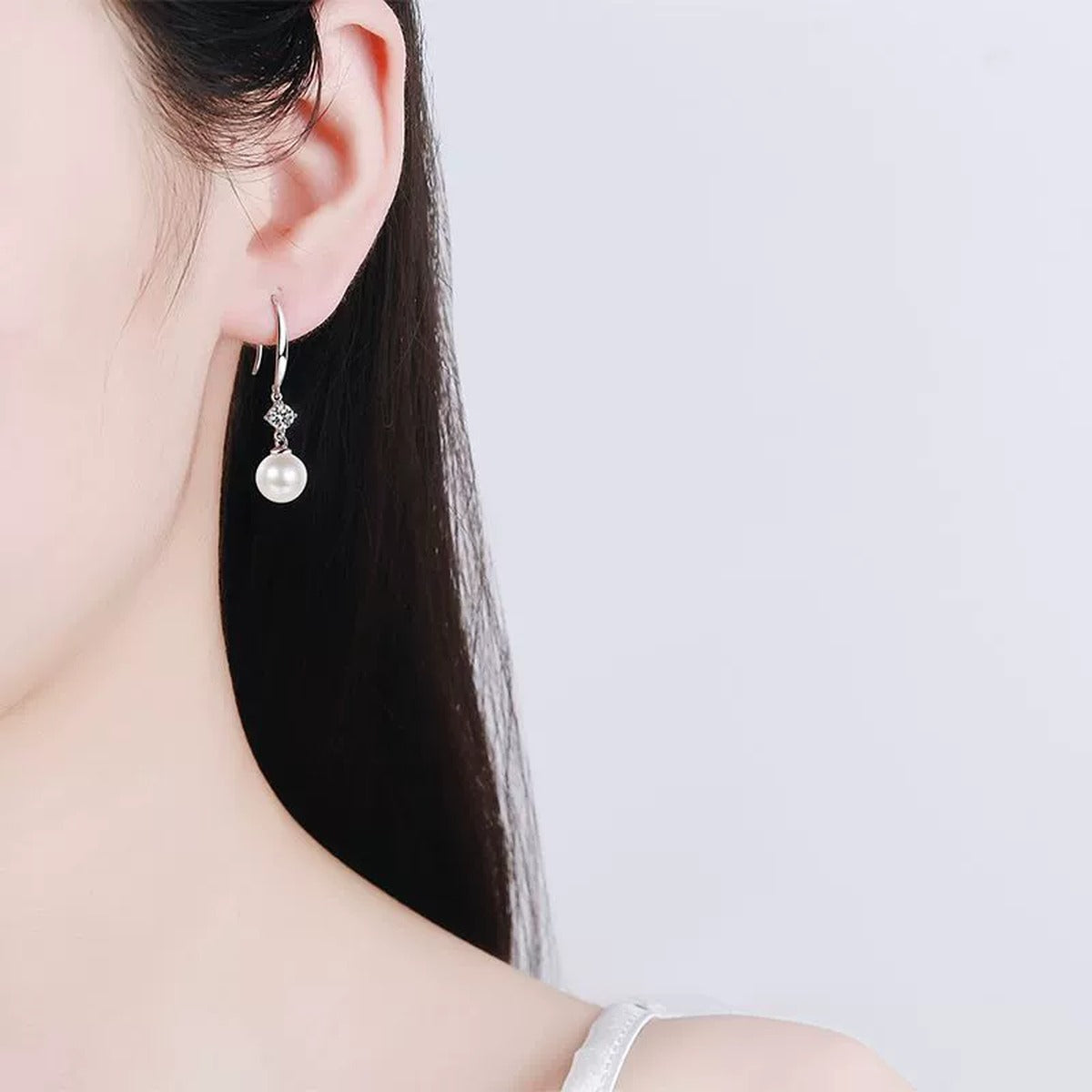 Pearl and Moissanite Hook Dangle Earrings in Rhodium-Plated S925 sterling silver worn on ear by model showing scale, placement, and hook dangle earrings styling