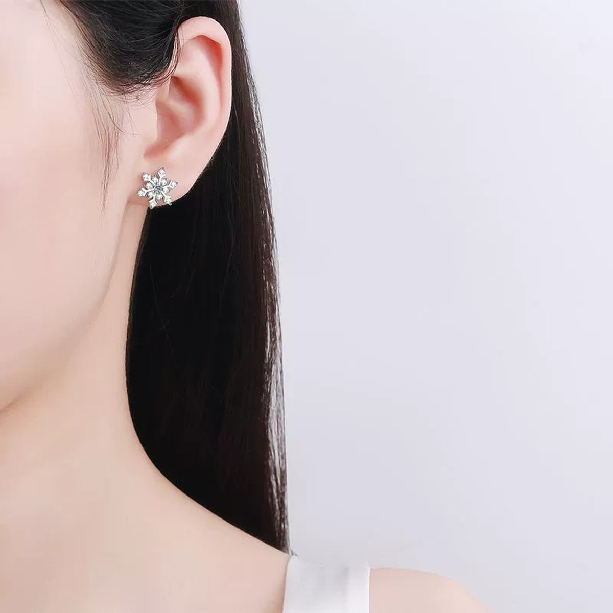 Snowflake Moissanite Stud Earrings in Rhodium-Plated S925 sterling silver worn on ear by model showing scale, placement, and stud earrings styling