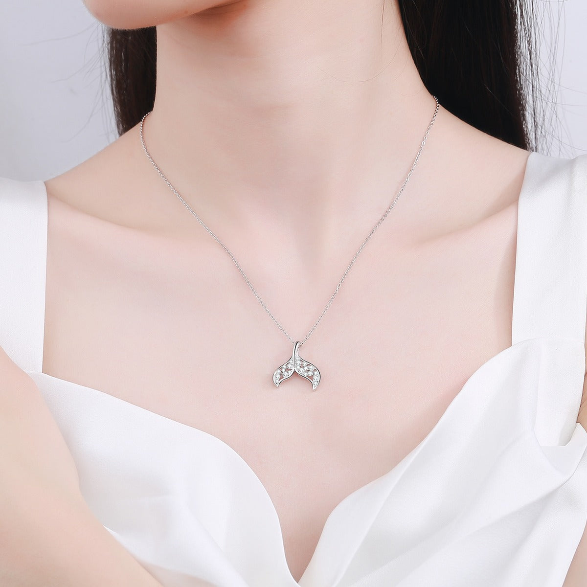 Whale Tail Moissanite Pendant Necklace in Rhodium-Plated S925 sterling silver worn on neckline by model showing scale and adjustable chain styling