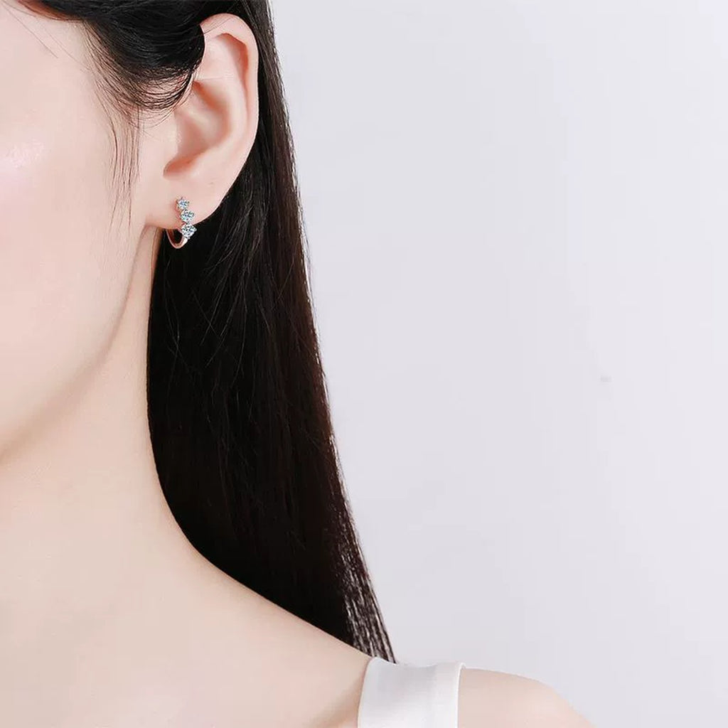 Graduated Moissanite Huggie Hoop Earrings in Rhodium-Plated S925 sterling silver worn on ear by model showing scale, placement, and huggie hoop earrings styling