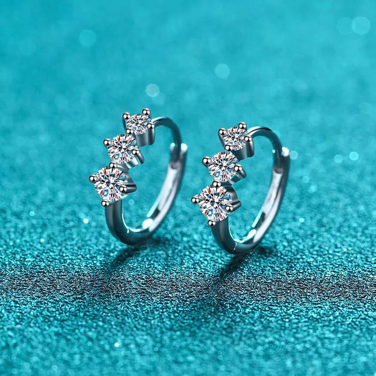 Graduated Moissanite Huggie Hoop Earrings in Rhodium-Plated S925 sterling silver product scene view showing front sparkle