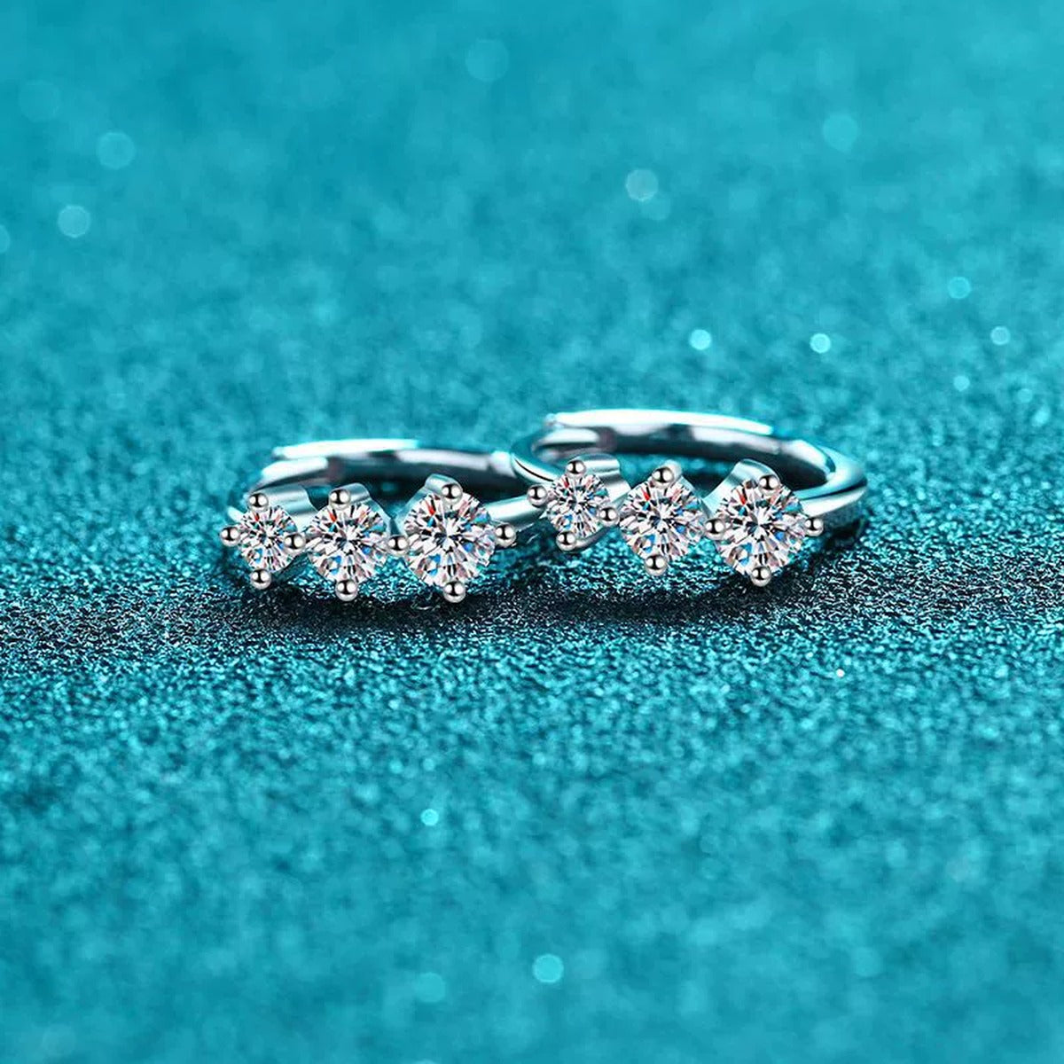 Graduated Moissanite Huggie Hoop Earrings in Rhodium-Plated S925 sterling silver product scene view showing angled setting detail