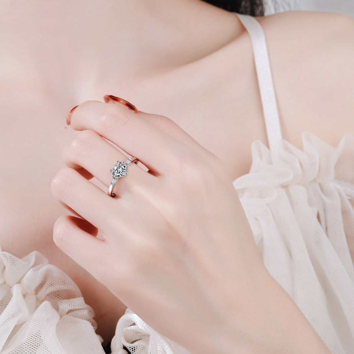 Heart Cut Moissanite Side Stone Engagement Ring with CZ worn on hand to show scale, band width, and ring profile