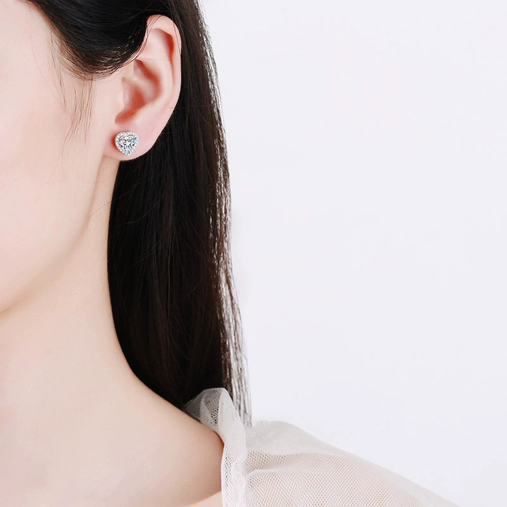 Heart Moissanite Stud Earrings with CZ in Rhodium-Plated S925 sterling silver worn on ear by model showing scale, placement, and stud earrings styling