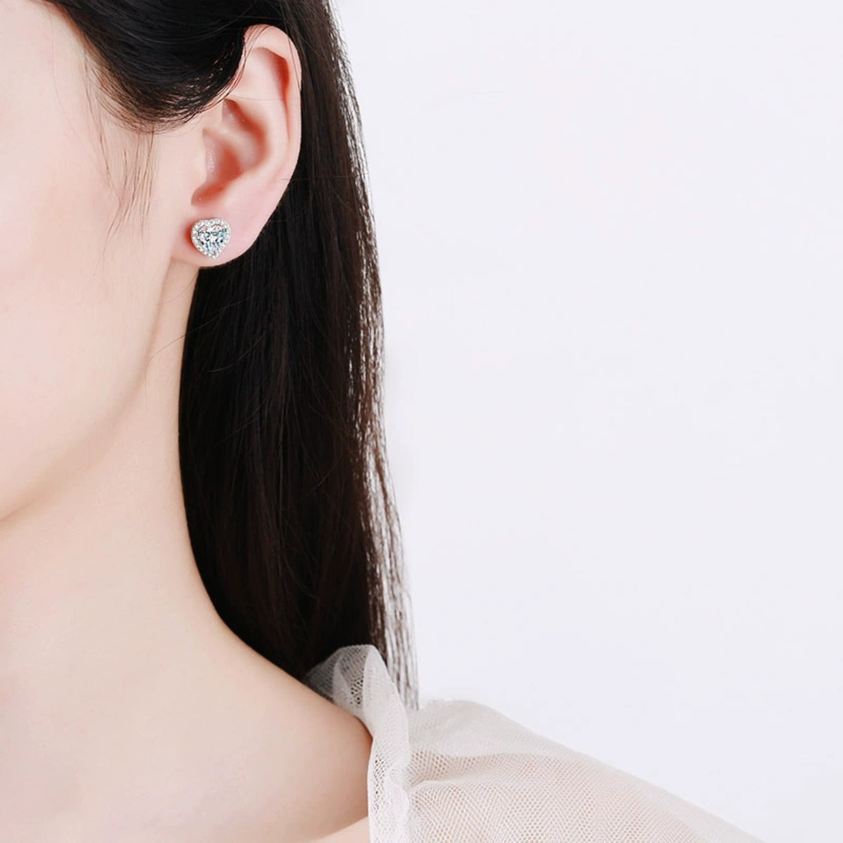Heart Moissanite Stud Earrings with CZ in Rhodium-Plated S925 sterling silver worn on ear by model showing scale, placement, and stud earrings styling