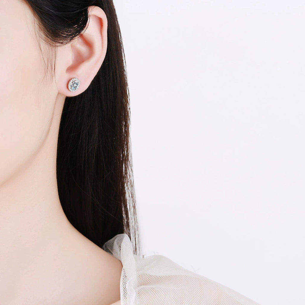 Oval Moissanite Stud Earrings with CZ in Rhodium-Plated S925 sterling silver worn on ear by model showing scale, placement, and stud earrings styling