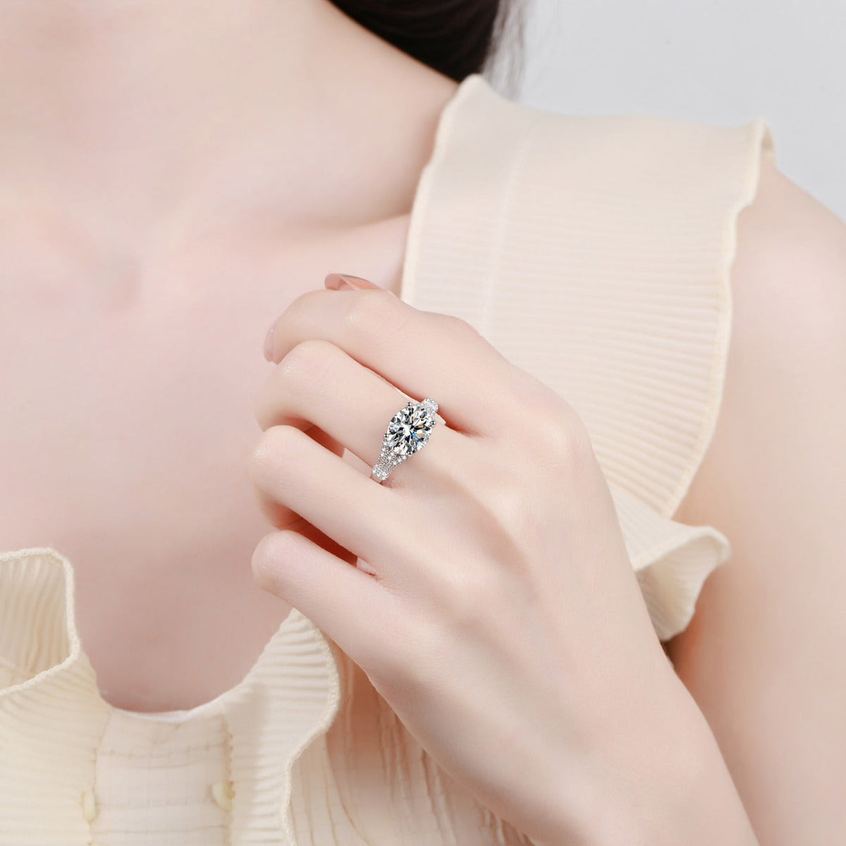 Oval Cut Moissanite Side Stone Engagement Ring with CZ worn on hand to show scale, band width, and ring profile