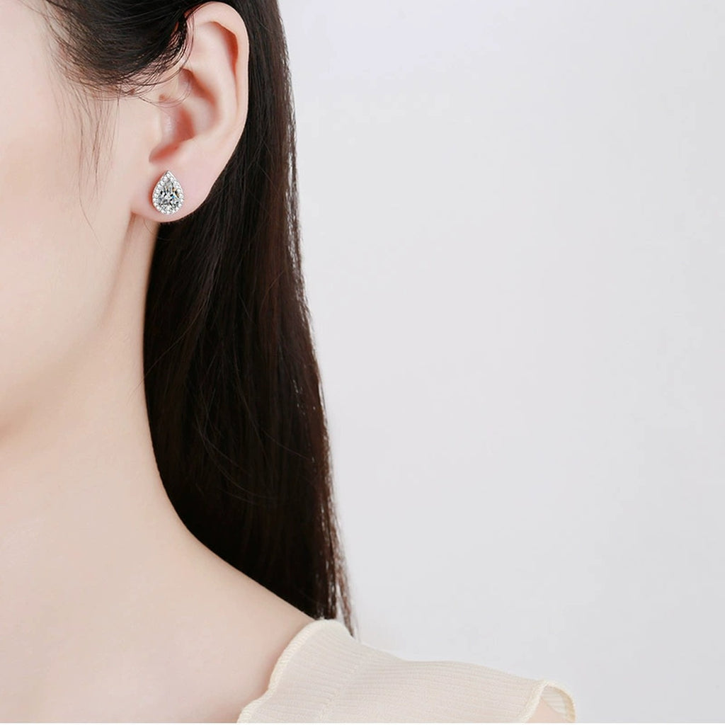 Pear Cut Moissanite Stud Earrings with CZ in Rhodium-Plated S925 sterling silver worn on ear by model showing scale, placement, and stud earrings styling