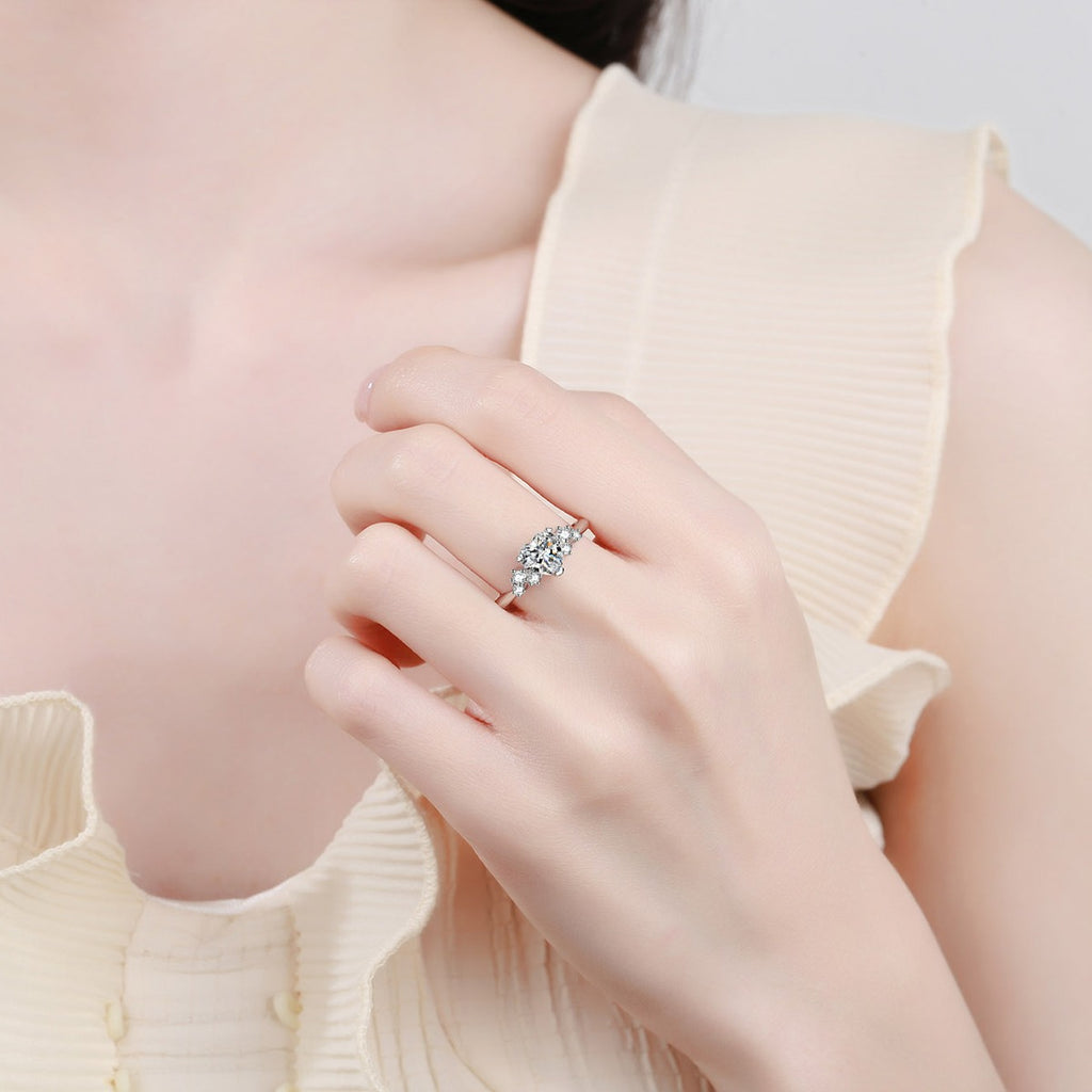 Heart Cut Moissanite Side Stone Engagement Ring with CZ in Rhodium-Plated S925 Sterling Silver worn on hand, showing scale, finger coverage, and rhodium-plated finish