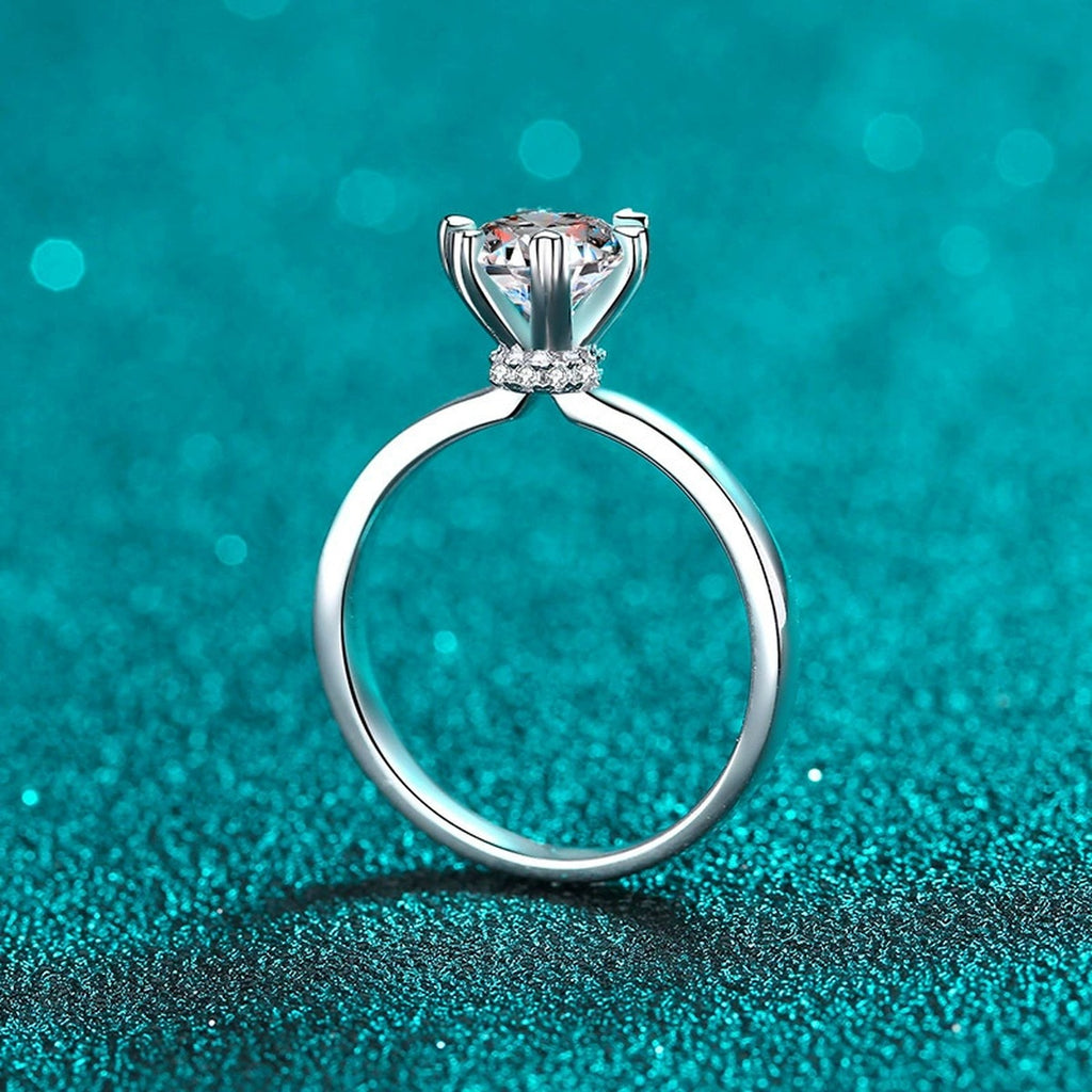 Round Moissanite Side Stone Engagement Ring with CZ in Rhodium-Plated S925 Sterling Silver blue display product photo showing the moissanite setting, stone cut, and band profile