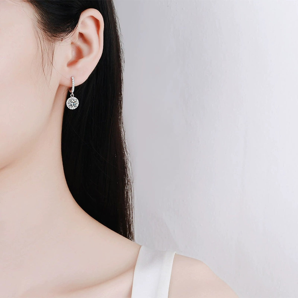 Round Halo Moissanite Hoop Dangle Earrings with CZ in Rhodium-Plated S925 sterling silver worn on ear by model showing scale, placement, and hoop dangle earrings styling