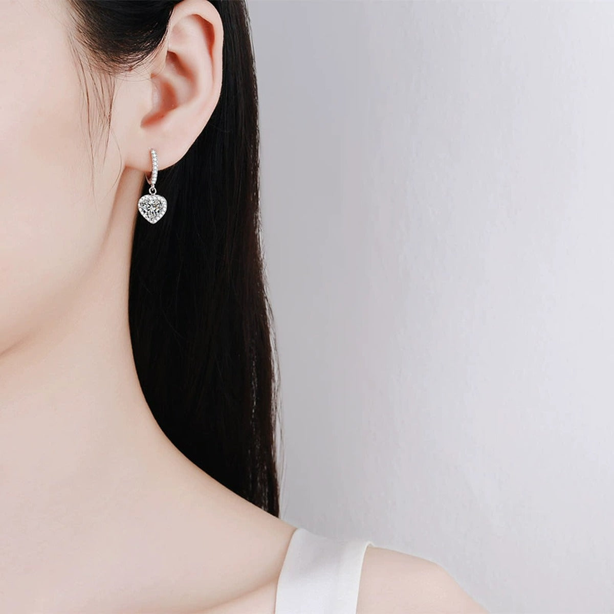 Heart Moissanite Hoop Dangle Earrings with CZ in Rhodium-Plated S925 sterling silver worn on ear by model showing scale, placement, and hoop dangle earrings styling