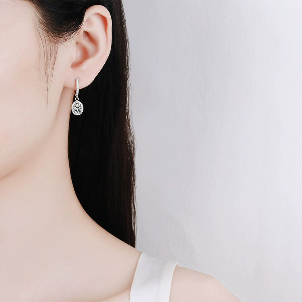 Oval Moissanite Hoop Dangle Earrings with CZ in Rhodium-Plated S925 sterling silver worn on ear by model showing scale, placement, and hoop dangle earrings styling