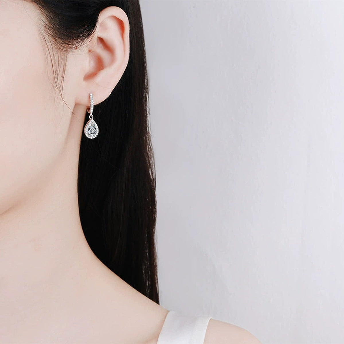 Pear Moissanite Hoop Dangle Earrings with CZ in Rhodium-Plated S925 sterling silver worn on ear by model showing scale, placement, and hoop dangle earrings styling
