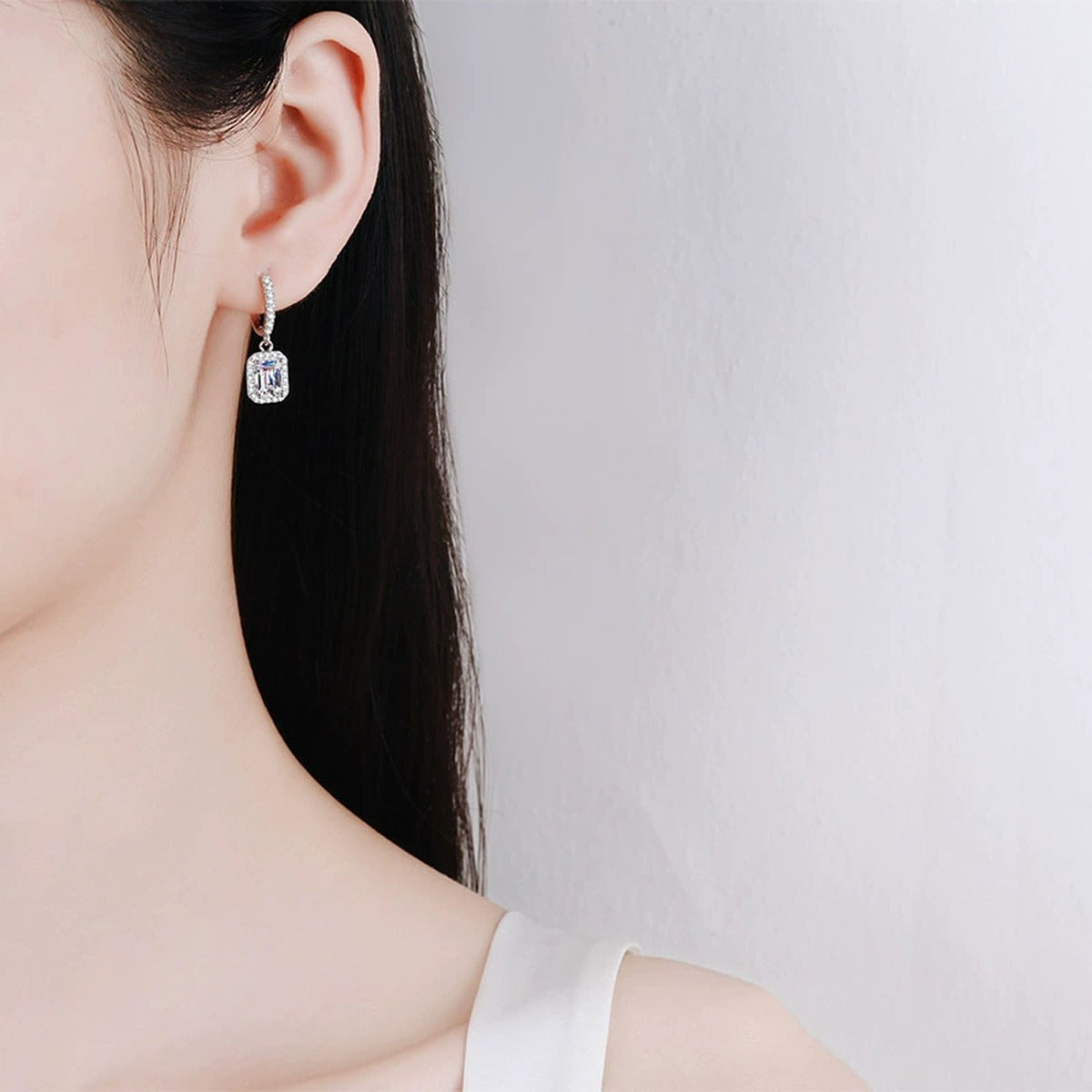 Emerald and Radiant Moissanite Hoop Dangle Earrings with CZ in Rhodium-Plated S925 sterling silver worn on ear by model showing scale, placement, and hoop dangle earrings styling