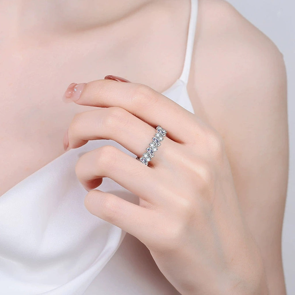 Round and Emerald Cut Moissanite Eternity Ring worn on hand to show scale and ring profile