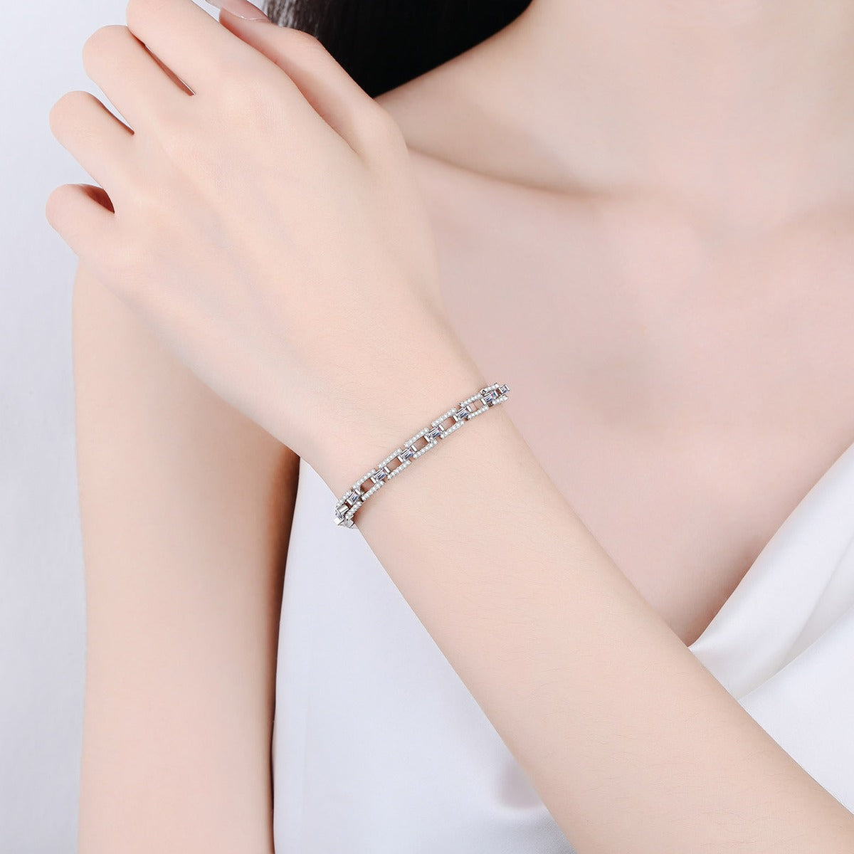 Emerald and Round Moissanite Tennis Bracelet in Rhodium-Plated S925 sterling silver worn on wrist model view showing scale and adjustable fit