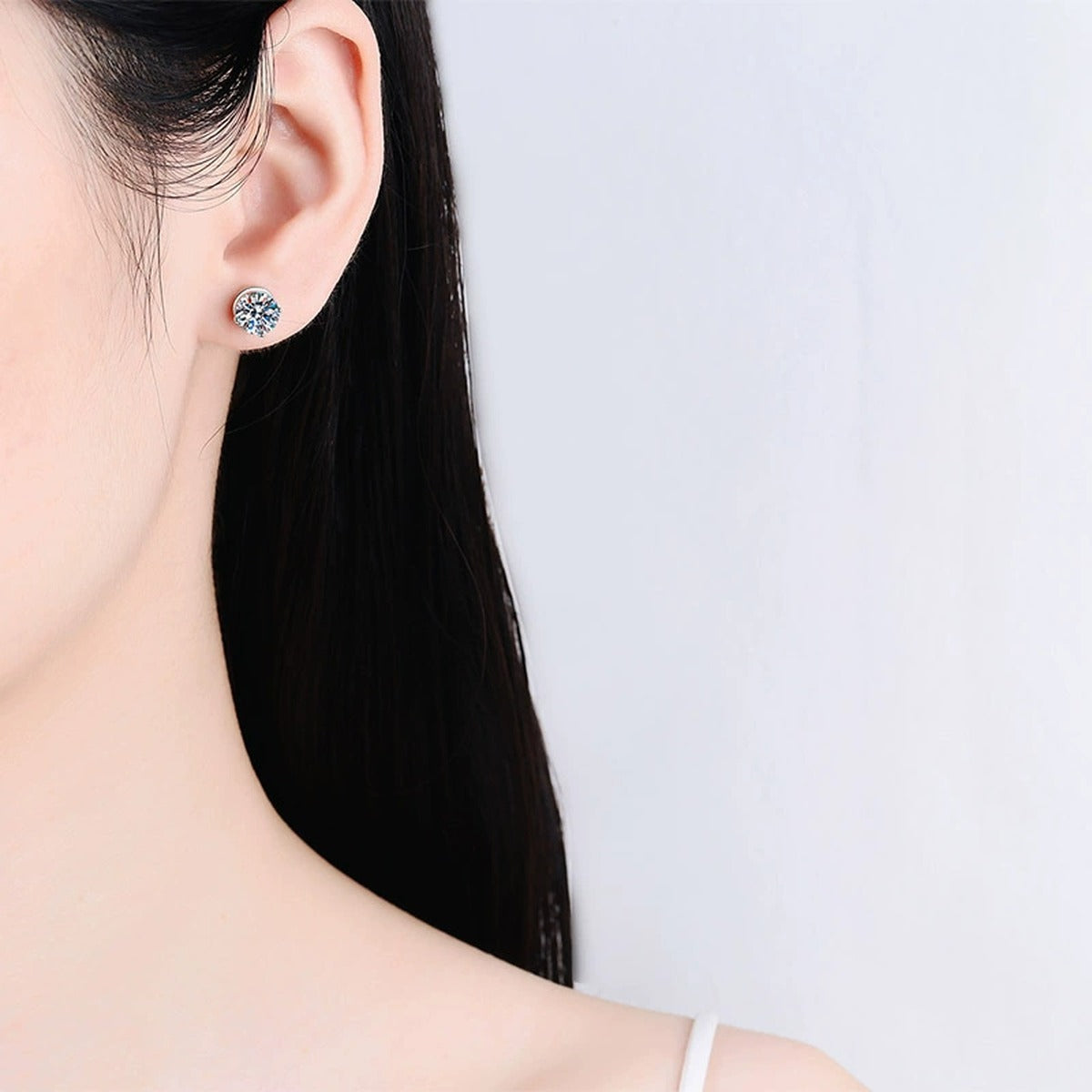 Round Moissanite Screw Back Stud Earrings in Rhodium-Plated S925 sterling silver worn on ear by model showing scale, placement, and stud earrings styling