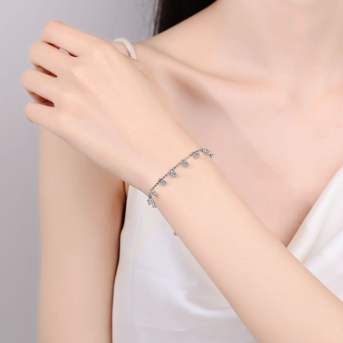 Moissanite Charm Station Bracelet in Rhodium-Plated S925 sterling silver worn on wrist model view showing scale and adjustable fit