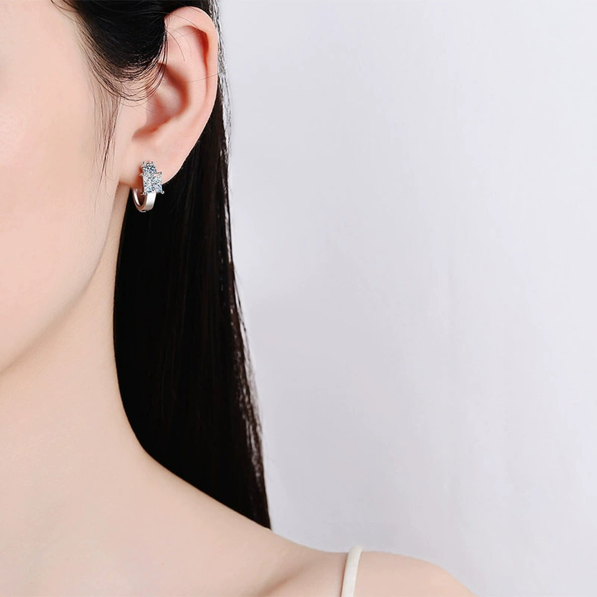 Princess and Round Moissanite Huggie Hoop Earrings in Rhodium-Plated S925 sterling silver worn on ear by model showing scale, placement, and huggie hoop earrings styling
