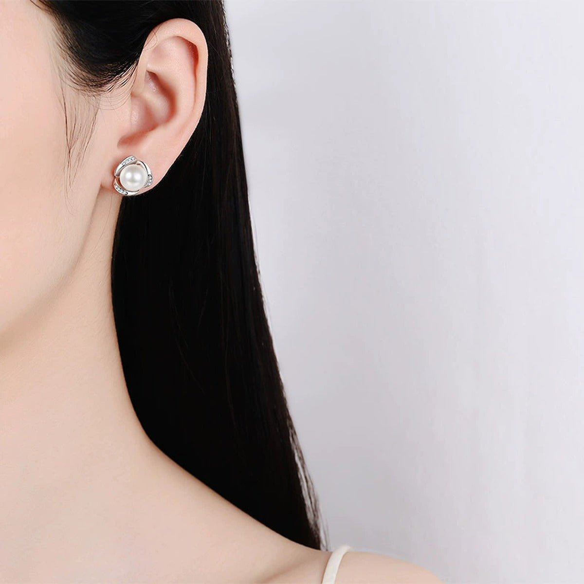 Twist Pearl and Moissanite Stud Earrings in Rhodium-Plated S925 sterling silver worn on ear by model showing scale, placement, and stud earrings styling