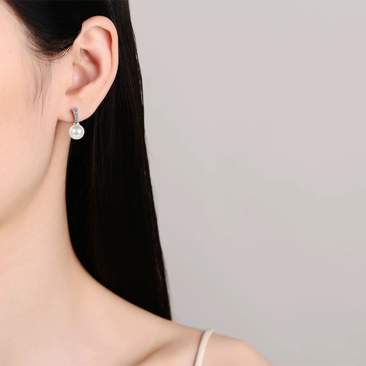 Pearl and Moissanite Stud Dangle Earrings in Rhodium-Plated S925 sterling silver worn on ear by model showing scale, placement, and stud dangle earrings styling