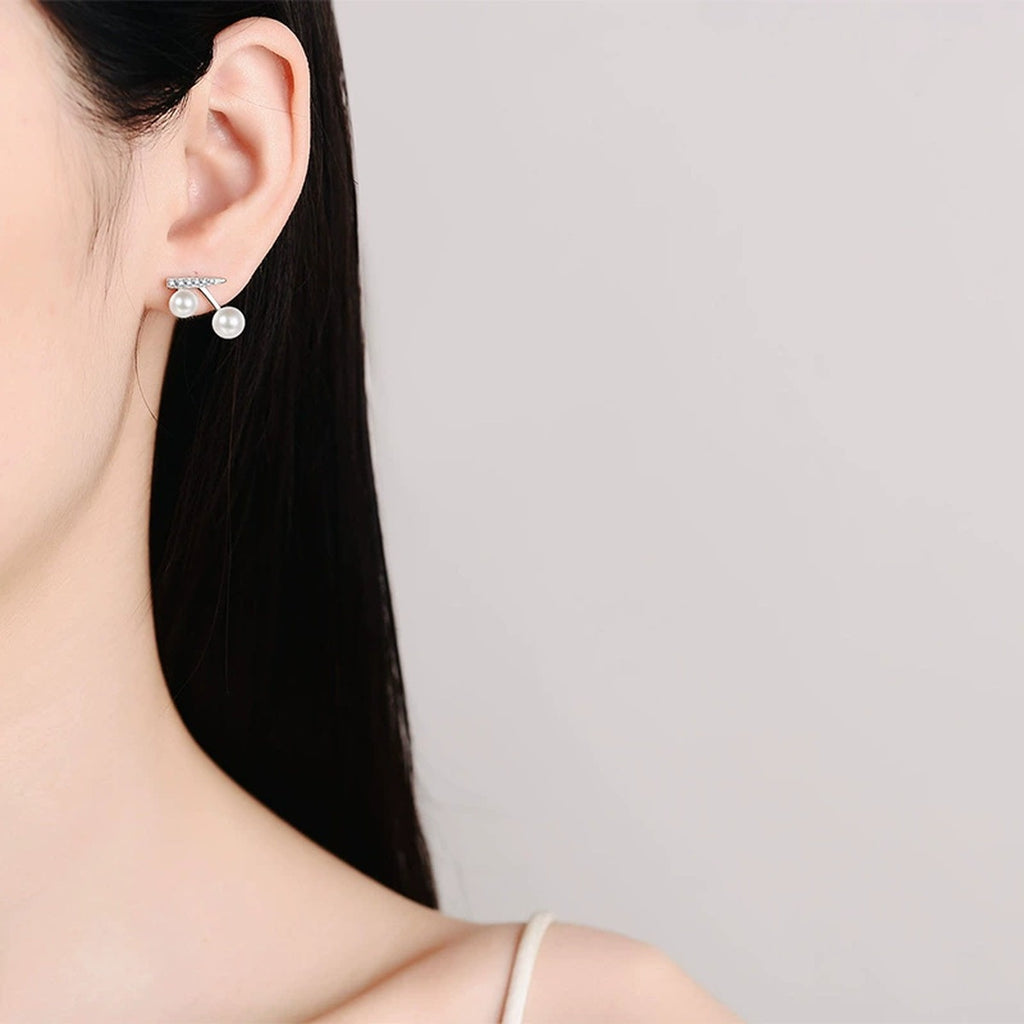 Cherry Pearl and Moissanite Stud Drop Earrings in Rhodium-Plated S925 sterling silver worn on ear by model showing scale, placement, and stud earrings styling