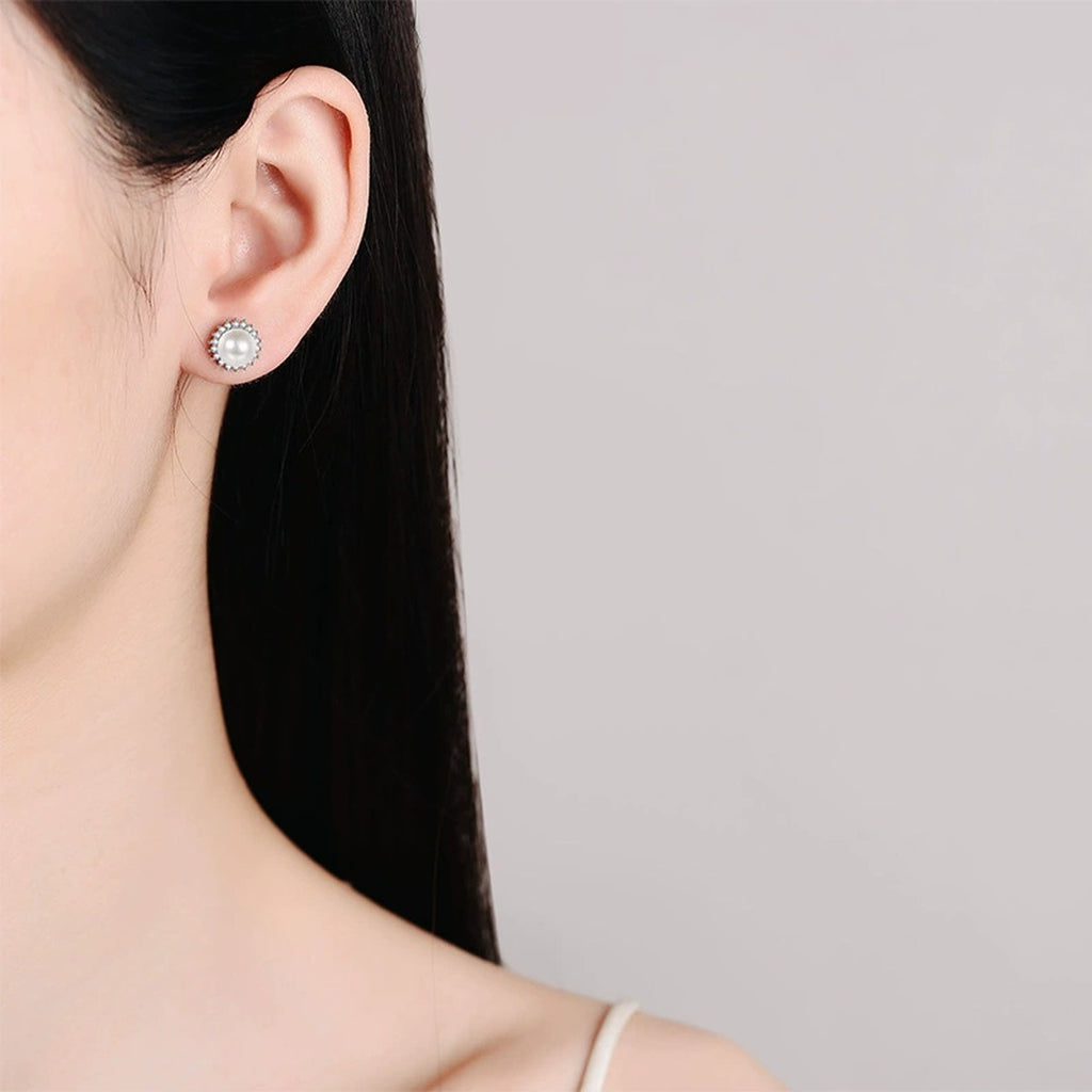 Pearl Halo Moissanite Stud Earrings in Rhodium-Plated S925 sterling silver worn on ear by model showing scale, placement, and stud earrings styling