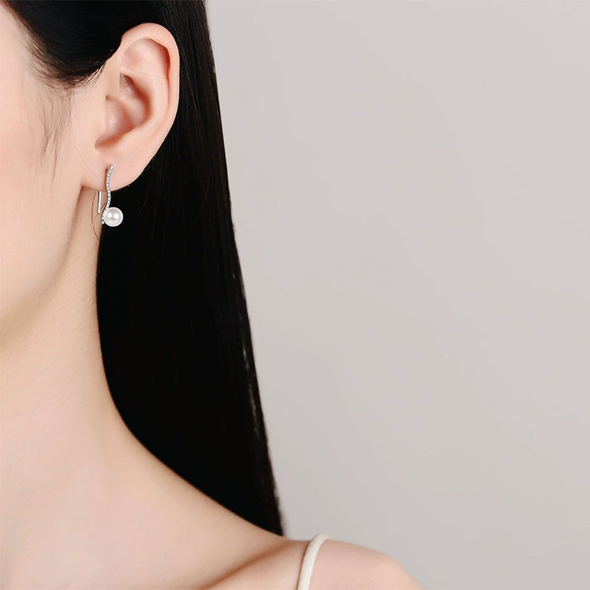 Pearl and Moissanite Hook Drop Earrings in Rhodium-Plated S925 sterling silver worn on ear by model showing scale, placement, and hook drop earrings styling