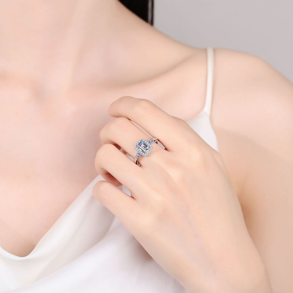 Emerald and Radiant Cut Moissanite Engagement Ring with CZ worn on hand to show scale, band width, and ring profile