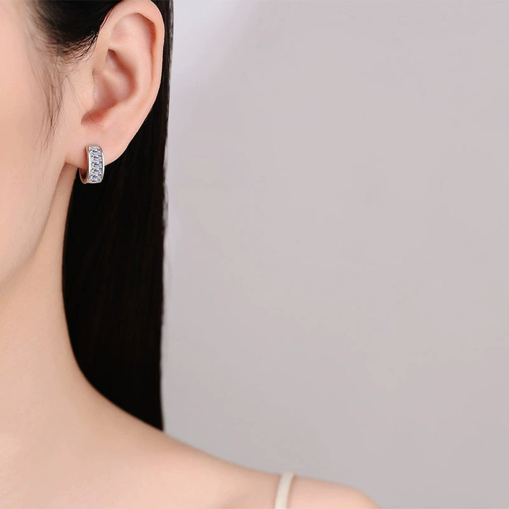Emerald Cut Moissanite Huggie Hoop Earrings in Rhodium-Plated S925 sterling silver worn on ear by model showing scale, placement, and huggie hoop earrings styling