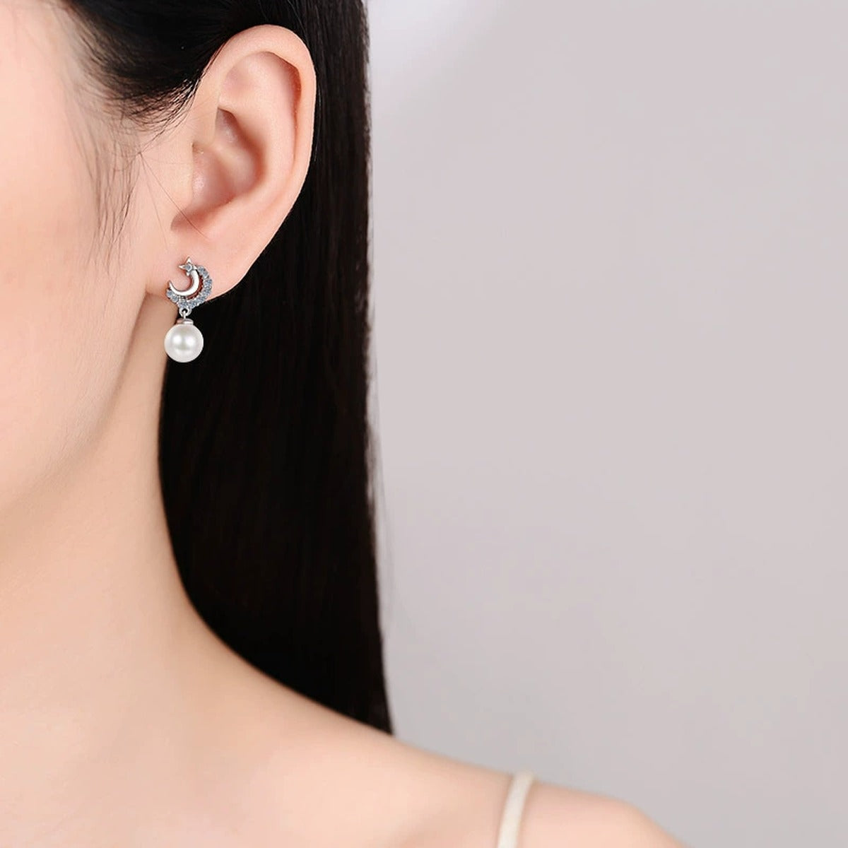 Crescent Star Pearl Moissanite Stud Dangle Earrings in Rhodium-Plated S925 sterling silver worn on ear by model showing scale, placement, and stud dangle earrings styling
