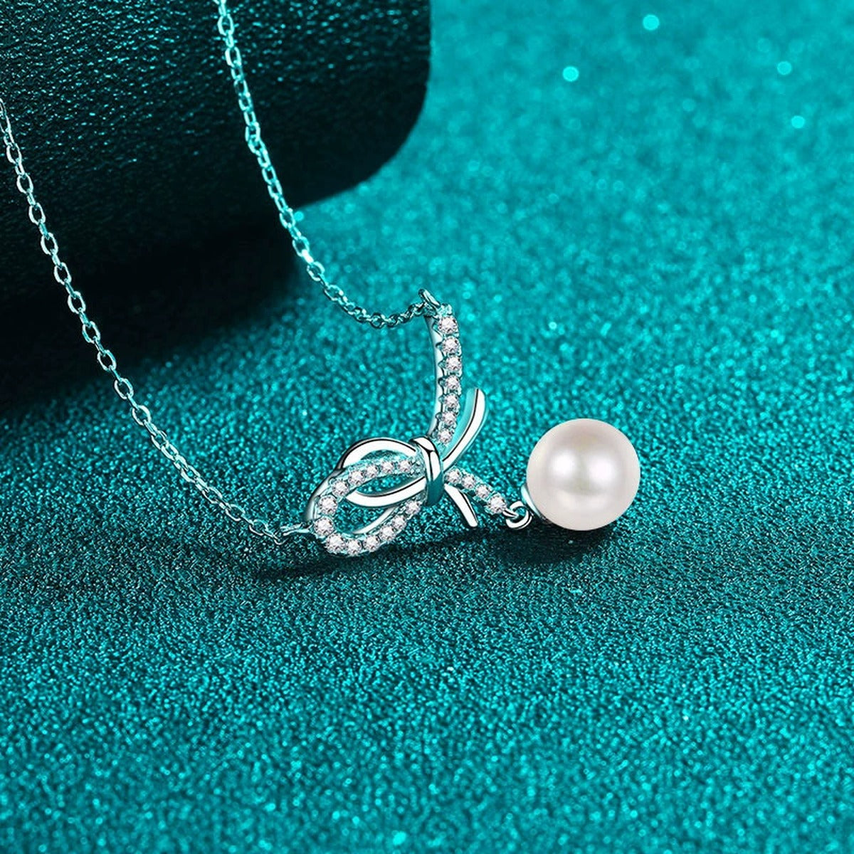 Bow Moissanite Pearl Pendant Necklace in Rhodium-Plated S925 sterling silver blue display scene showing chain and stone layout