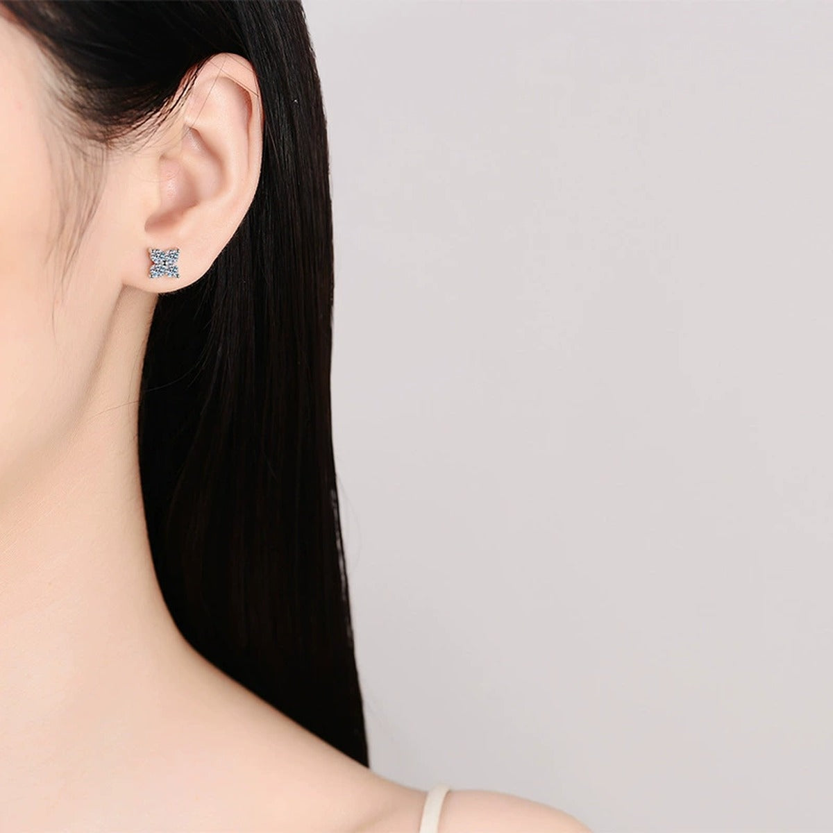 Starburst Moissanite Stud Earrings in Rhodium-Plated S925 sterling silver worn on ear by model showing scale, placement, and stud earrings styling