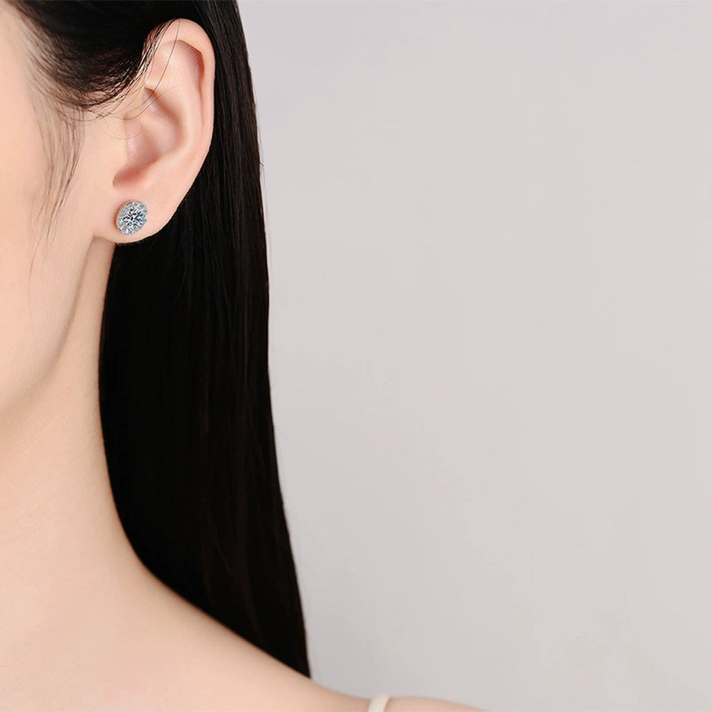 Oval Halo Round Moissanite Stud Earrings with CZ in Rhodium-Plated S925 sterling silver worn on ear by model showing scale, placement, and stud earrings styling