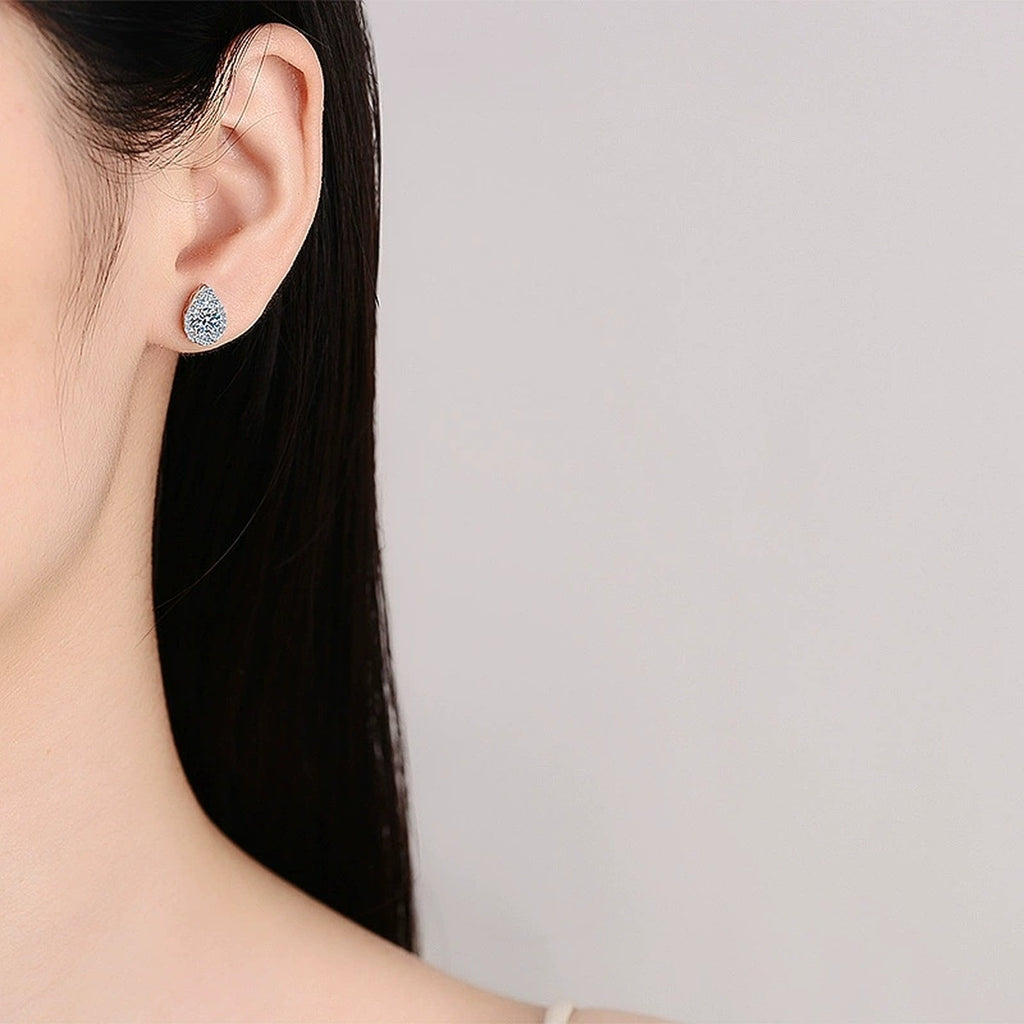 Pear Halo Round Moissanite Stud Earrings with CZ in Rhodium-Plated S925 sterling silver worn on ear by model showing scale, placement, and stud earrings styling