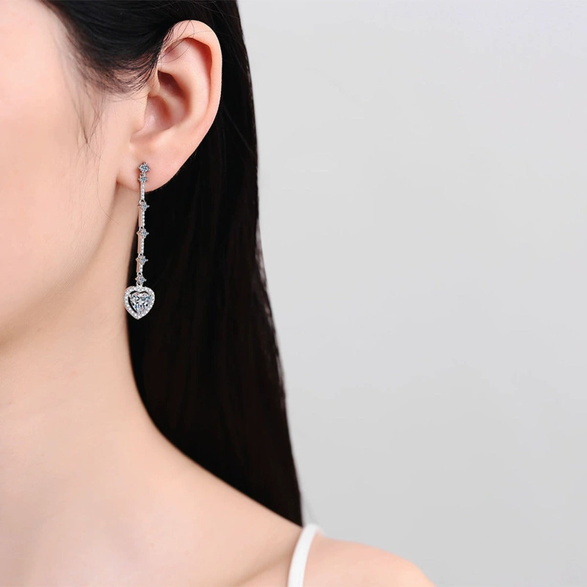 Heart Moissanite Stud Dangle Earrings with CZ in Rhodium-Plated S925 sterling silver worn on ear by model showing scale, placement, and stud dangle earrings styling