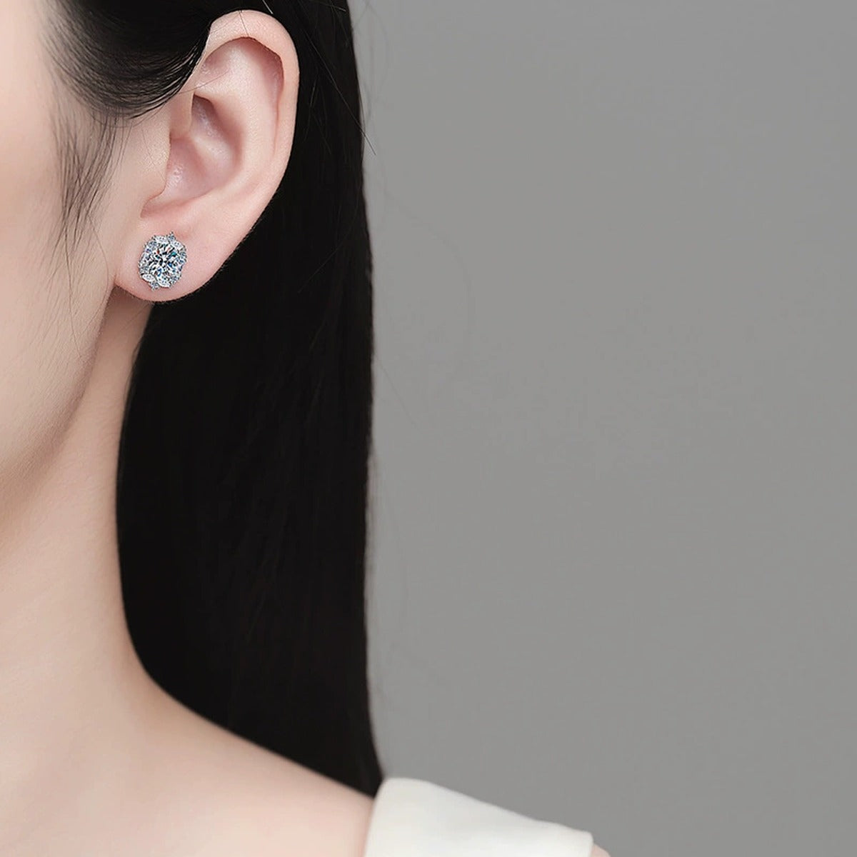 Oval Moissanite Stud Earrings with CZ in Rhodium-Plated S925 sterling silver worn on ear by model showing scale, placement, and stud earrings styling