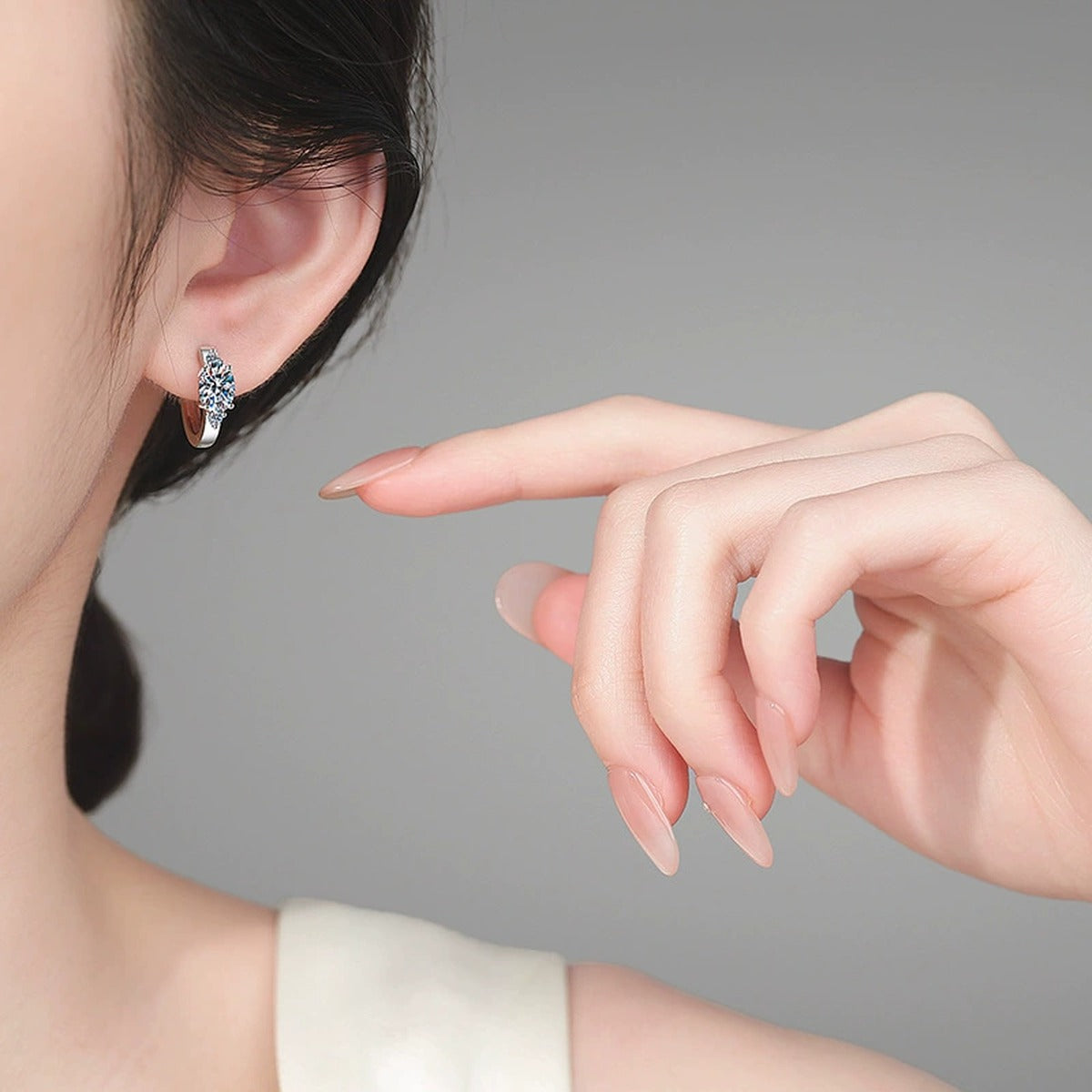 Oval Moissanite Hoop Earrings with CZ in Rhodium-Plated S925 sterling silver worn on ear by model showing scale, placement, and hoop earrings styling