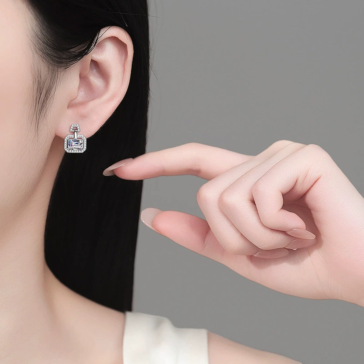 Emerald and Radiant Cut Moissanite Stud Drop Earrings with CZ in Rhodium-Plated S925 sterling silver worn on ear by model showing scale, placement, and stud earrings styling