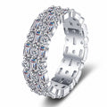 Emerald and Round Moissanite Eternity Band Ring in rhodium-plated S925 sterling silver on clean white background