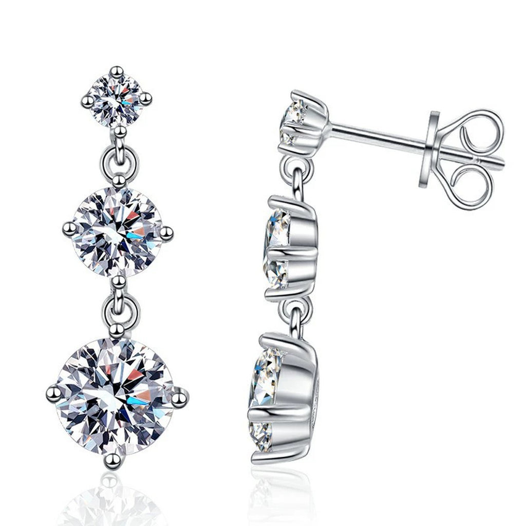 Graduated Moissanite Drop Earrings in White Gold-Plated S925 Sterling Silver on clean white background showing the pair and graduated three-stone drop earrings with round moissanite stones