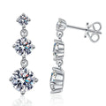 Graduated Moissanite Drop Earrings in White Gold-Plated S925 Sterling Silver on clean white background showing the pair and graduated three-stone drop earrings with round moissanite stones