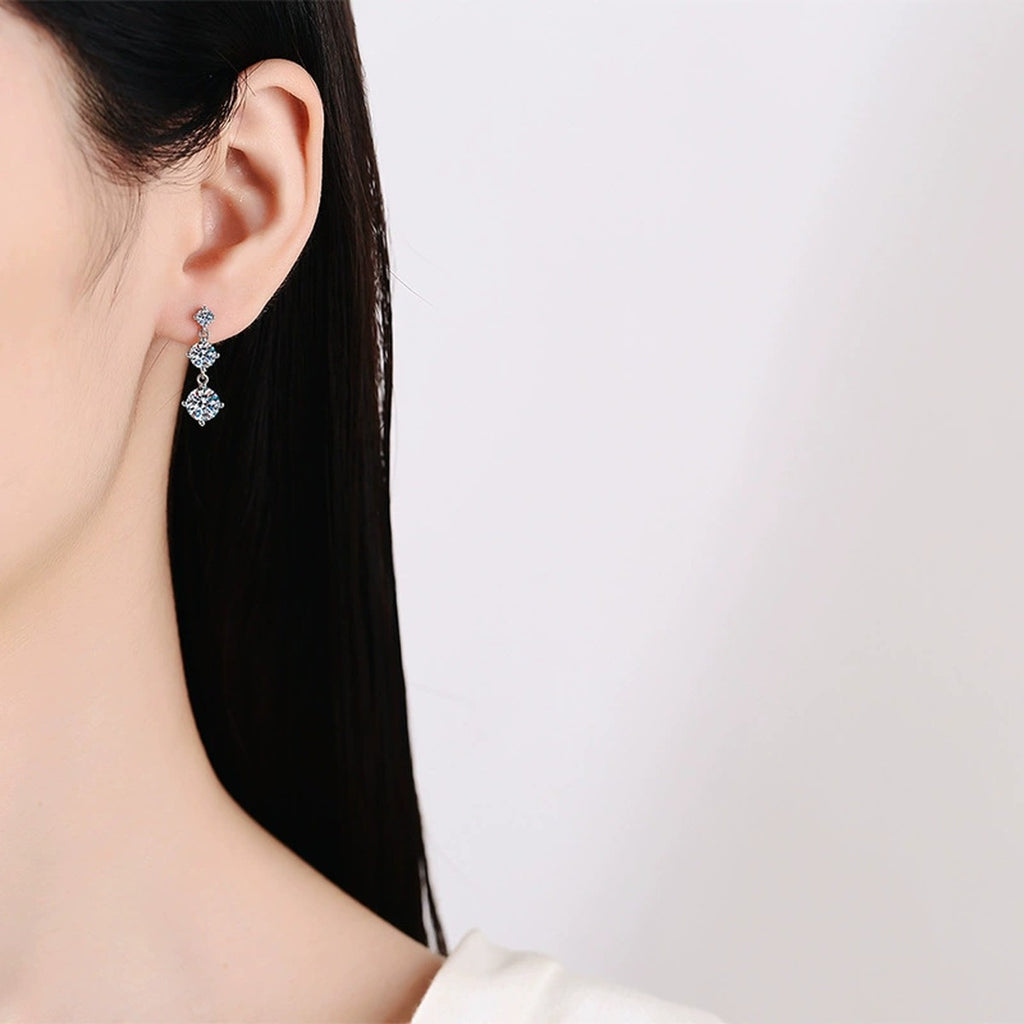 Graduated Moissanite Drop Earrings in White Gold-Plated S925 Sterling Silver worn on ear by model